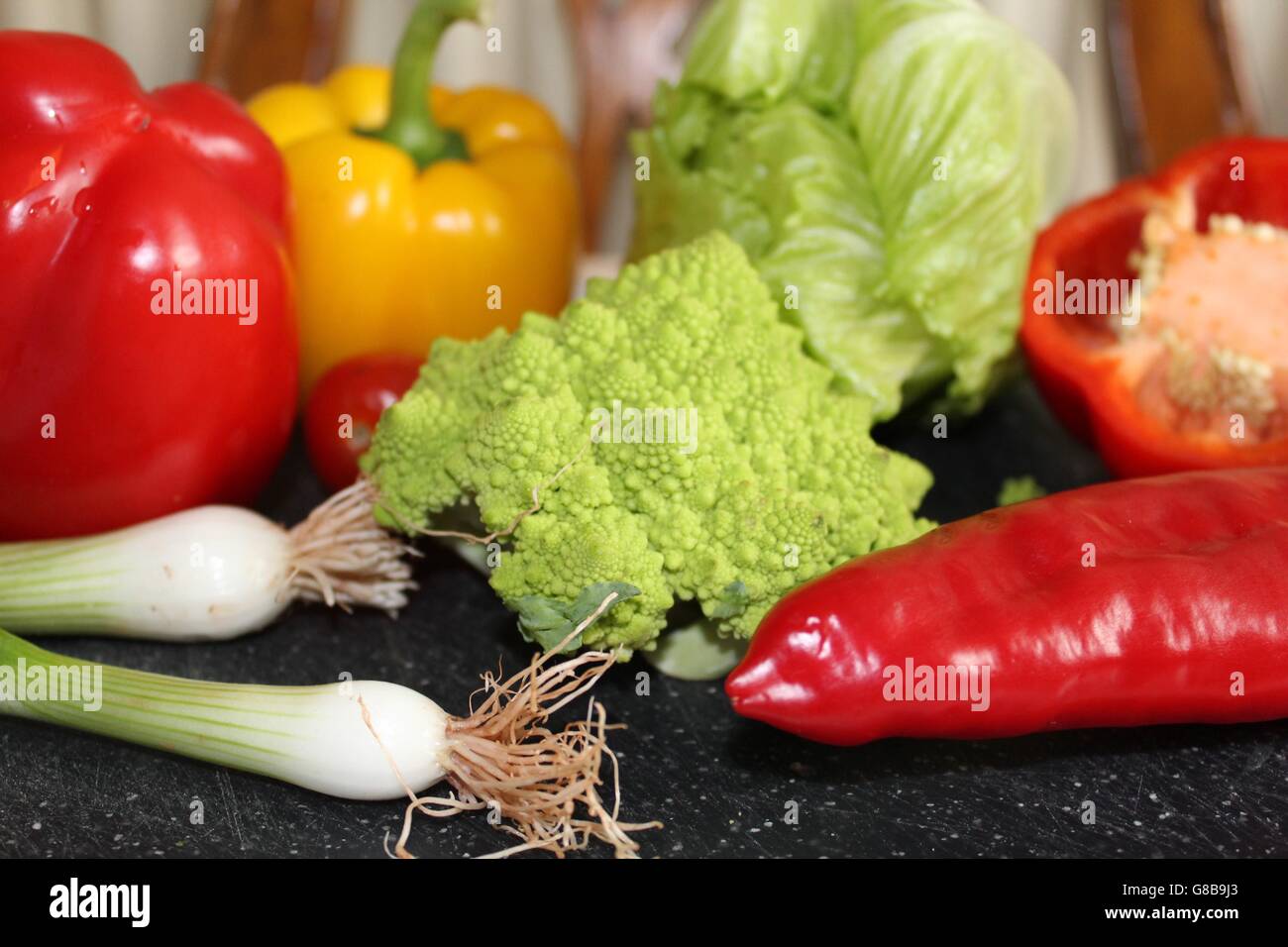 Vivaci e colorate, verdure fresche, compresi peperoni, romanesco broccoli, cipolline e lattuga. Foto Stock