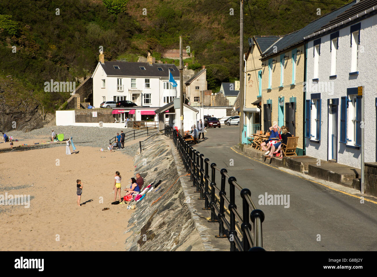 Regno Unito, Galles Ceredigion, Llangrannog, case sul lungomare e la spiaggia nella luce del pomeriggio Foto Stock