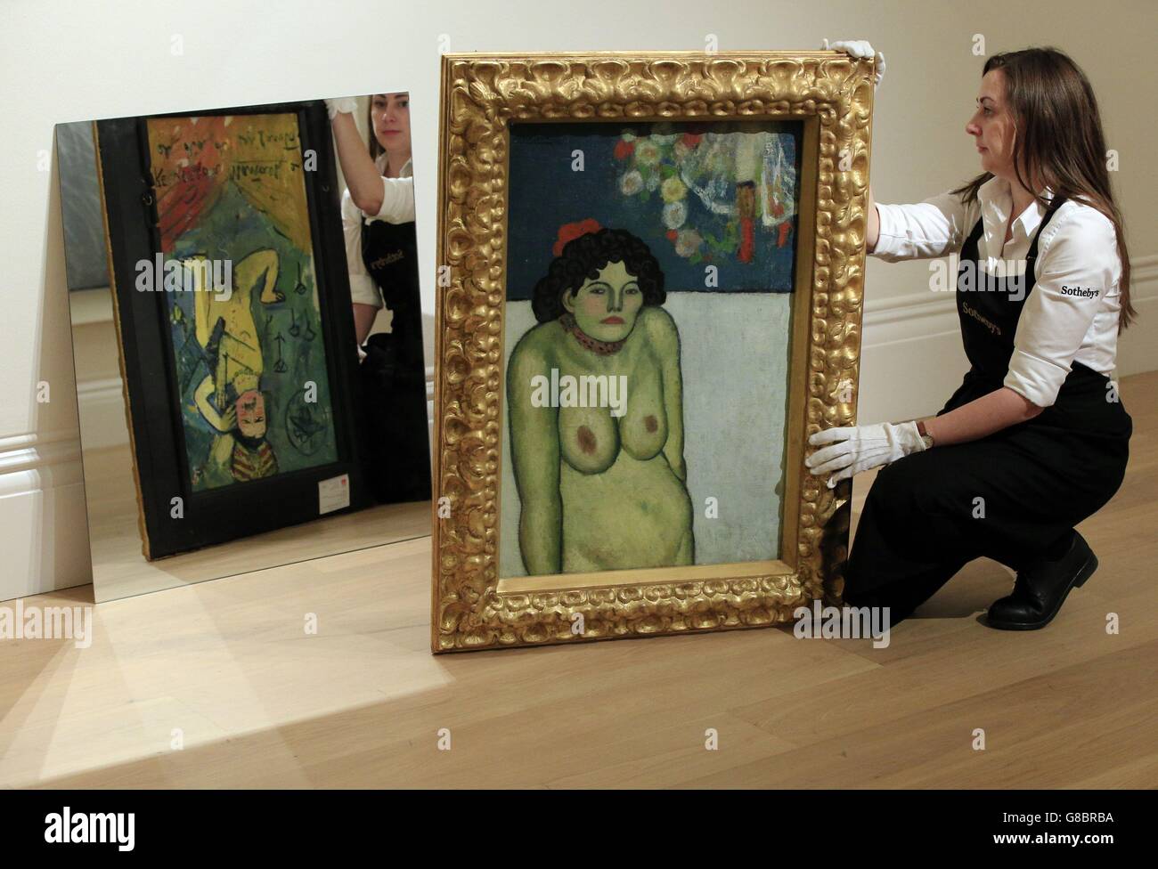 L'assistente di Sotheby espone la 'la Gommeuse' di Picasso, con il suo lato opposto riflesso in uno specchio durante un'anteprima stampa nel centro di Londra per la vendita serale di New York Impressionist e Modern Art della casa d'aste. Foto Stock