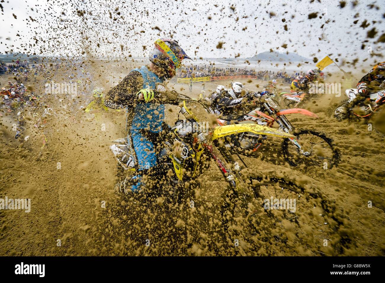 I piloti che si trovano nella gara solitaria maschile si affrontano con una duna al Weston Beach Race, Weston-super-Mare, dove la spiaggia viene trasformata in una pista ciclabile fangosa. Foto Stock