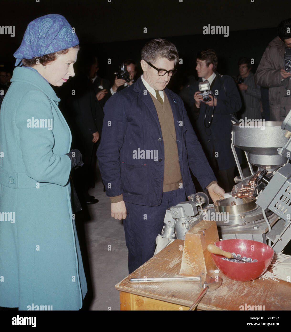 La regina guarda le banche di moneta che vengono alimentate nella macchina che goffrano con il nuovo valore decimale di conio dopo l'apertura della nuova zecca reale a Llantrisant, Glamorgan, Galles. Foto Stock