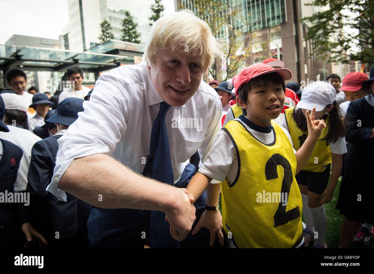 Il sindaco di Londra Boris Johnson partecipa a un torneo Street Rugby in una strada di Tokyo con bambini e adulti della scuola di Nihonbashi, Yaesu &amp; Kyobashi Community Associations, per celebrare il Giappone che ospita la Coppa del mondo di rugby 2019, dove il signor Johnson è l'ultimo giorno della sua visita commerciale di quattro giorni in Giappone. Foto Stock