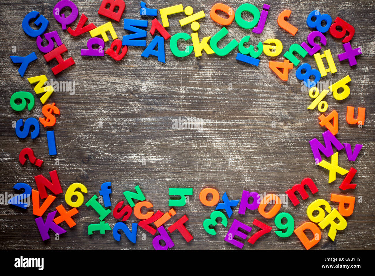 Bordo superiore del magnetico colorato lettere e numeri su un sfondo di legno Foto Stock