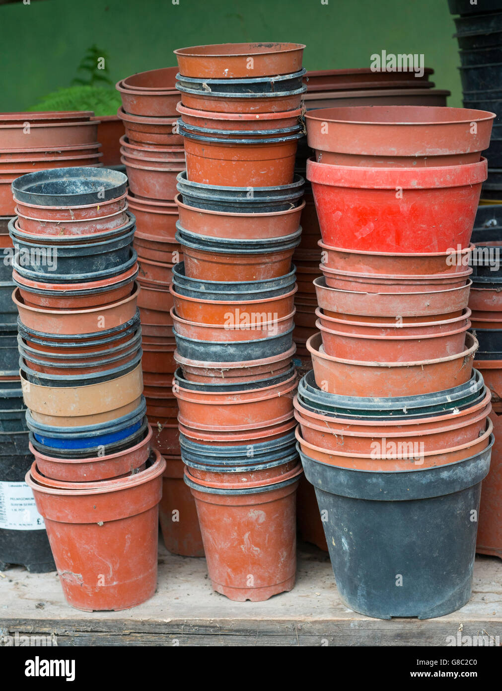 In plastica vuota vasi per piante impilati su un ripiano in un polytunnel. Foto Stock