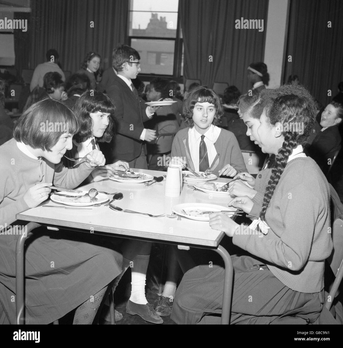 I bambini britannici, grecociprioti e dell'India occidentale, tra gli altri, gusterete il pranzo nella sala da pranzo dell'Archway Comprehensive School. Quattrocento dei 920 alunni della scuola sono immigrati, provenienti da un'ampia varietà di nazionalità. Foto Stock