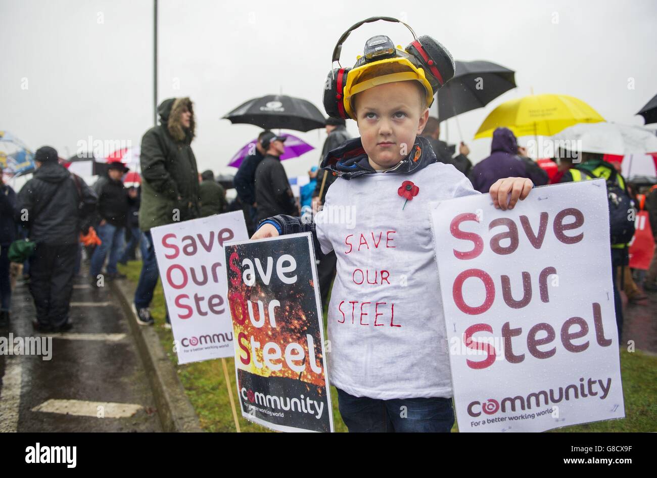 Rory Carrigan, di cinque anni, si unì a sua madre e a centinaia di lavoratori siderurgici per attraversare le strade di Motherwell per salvare il lavoro e impedire la chiusura dell'industria siderurgica in Scozia. PREMERE ASSOCIAZIONE foto. Data immagine: Sabato 7 novembre 2015. Lo scorso mese, la ditta siderurgica Tata ha annunciato la modificazione delle sue attività presso gli stabilimenti del Lanarkshire Dalzell a Motherwell e Clydebridge a Cambuslang, con la perdita di 270 posti. Lavoratori, leader sindacali e sostenitori hanno marciato da Dalzell al sito delle ex opere siderurgiche Ravenscraig oggi a sostegno di un’azione per salvare il Foto Stock