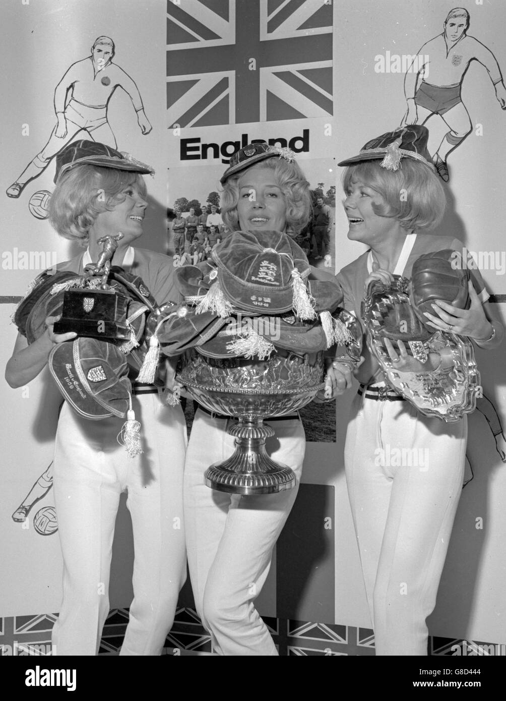 I cappelli e i trofei di Billy Wright sono tenuti da sua moglie Joy (centro) e le altre due Beverley Sisters Babs (l) e Teddy alla Football International Exhibition di Simpsons a Piccadilly, Londra. Foto Stock
