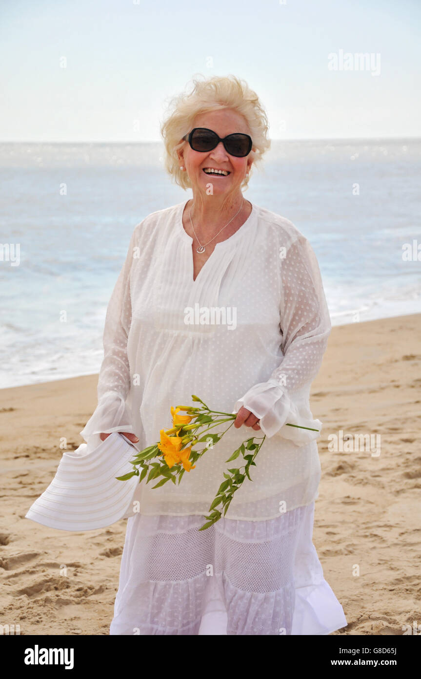 Senior signora sorridente e attivo presso la spiaggia Foto Stock Senior signora sorridente e attivo presso la spiaggia Foto Stock