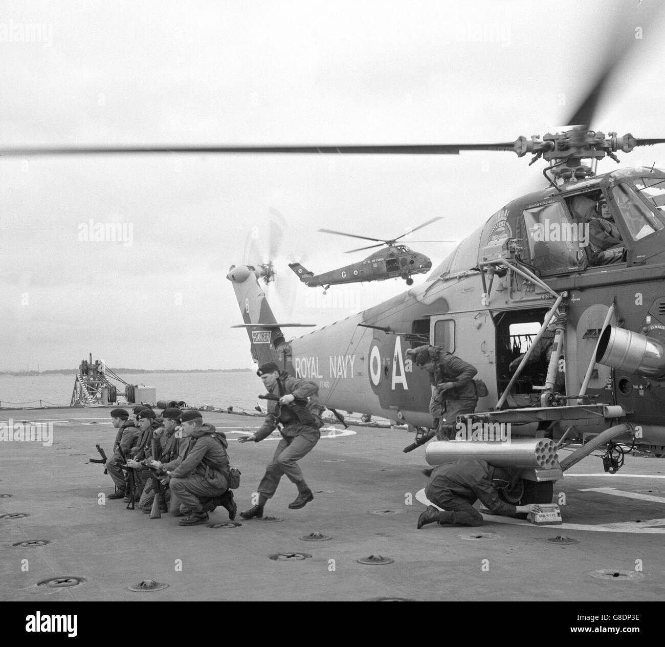 I Royal Marines si diranno dal ventre di un elicottero Royal Air Force al ponte della nuova nave d'assalto HMS Fearless della Royal Navy durante una dimostrazione della versatilità dell'imbarcazione a Lee-on-Solent, Hampshire. L'impaurita è la prima nave di sbarco della Marina e può trasportare circa 400 truppe con un numero significativo di carri armati, veicoli e attrezzature pesanti. Foto Stock