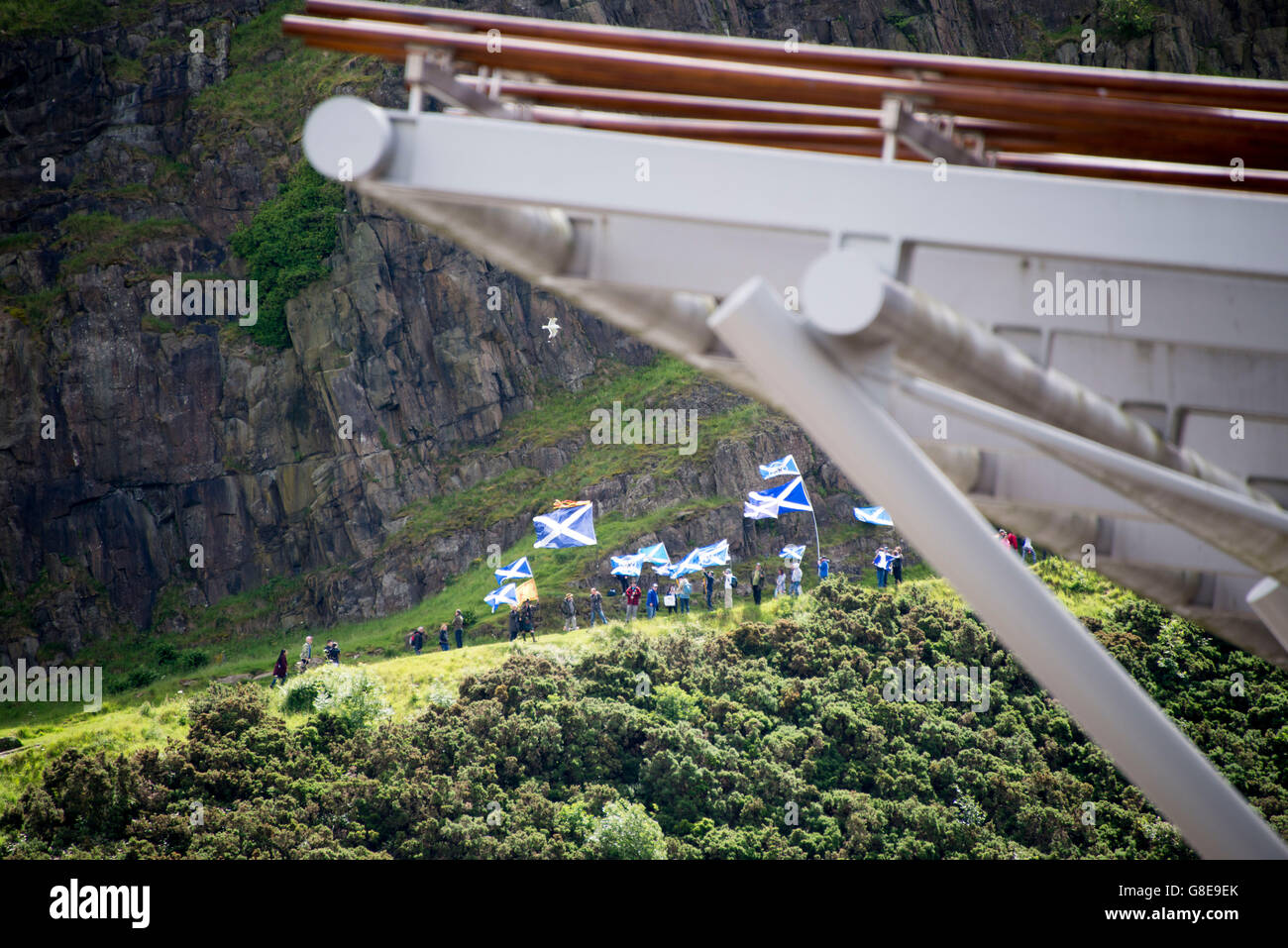 Eddinburgh, Scotland, Regno Unito. 02Luglio, 2016. I nazionalisti scozzesi sventolare la bandiera si intraversa dalla radicale strada si affaccia il parlamento scozzese. La regina apre la quinta sessione del Parlamento scozzese. La quinta legislatura del Parlamento scozzese è iniziata dopo il maggio l'Holyrood elezioni e MSP hanno avuto la loro ultima sessione prima della pausa estiva il giovedì. A seguito della cerimonia di apertura, migliaia di persone hanno preso parte alla processione a cavallo lungo il Royal Mile, guidato dalla banda del Reggimento reale della Scozia. Credito: Andrew O'Brien/Alamy Live News Foto Stock