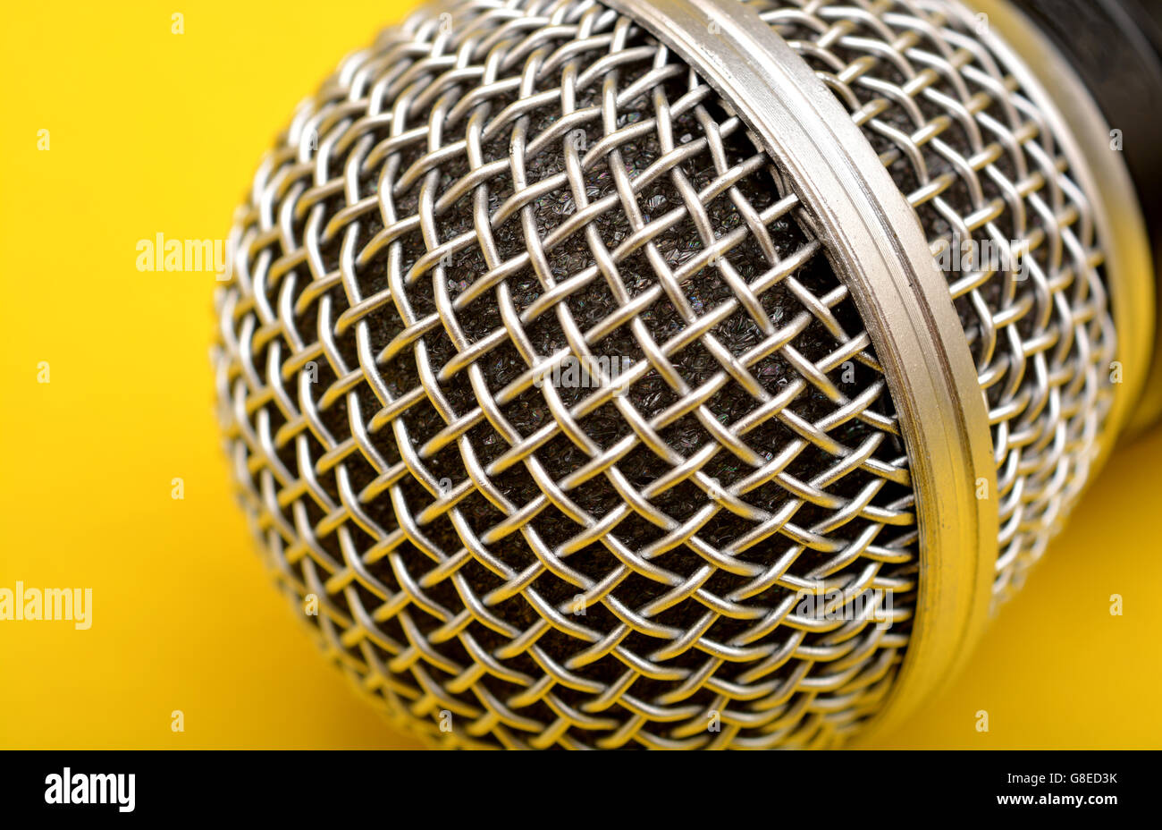 Microfono wireless close up su sfondo giallo - oratore motivazionale concept Foto Stock