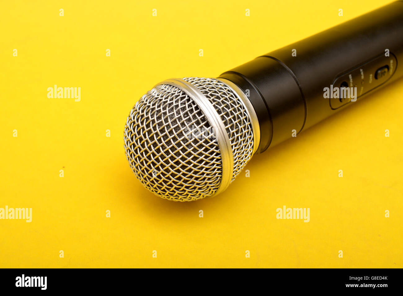 Microfono wireless su sfondo giallo - oratore motivazionale concetto. Foto Stock