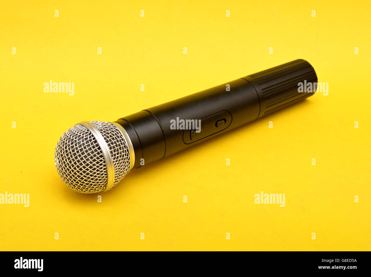 Microfono wireless su sfondo giallo - oratore motivazionale concetto. Foto Stock