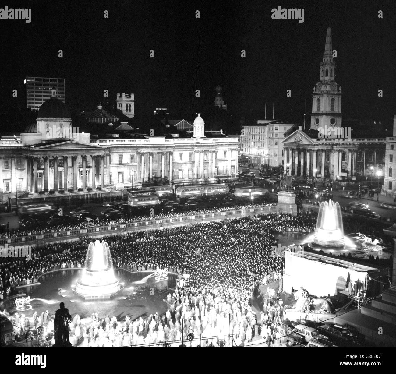 Una grande folla si riunisce in Trafalgar Square mentre i risultati delle elezioni generali vengono raggiunti. Sullo sfondo si trova la Galleria Nazionale illuminata. Foto Stock