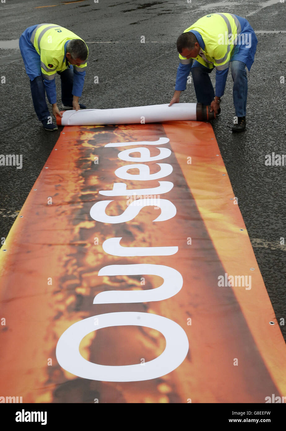 Un banner Save Our Steel viene arrotolato fuori da Tata Steel Dalzell a Motherwell, Scozia, prima di salire a bordo di un pullman diretto al Parlamento scozzese per partecipare a un dibattito sul futuro dell'industria. Foto Stock