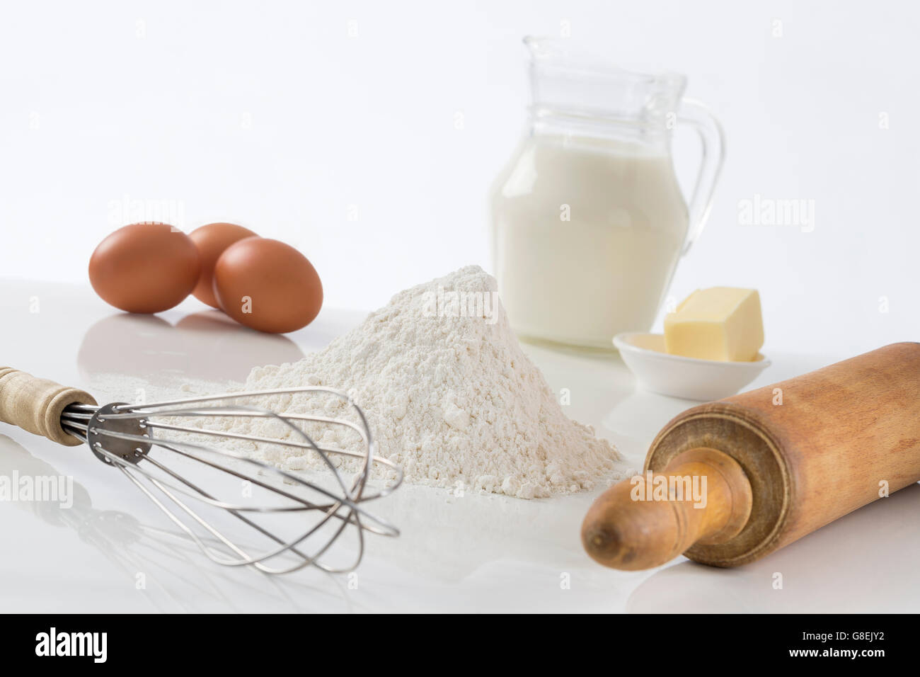 Uova, farina, latte, burro e utensili da cucina Foto Stock