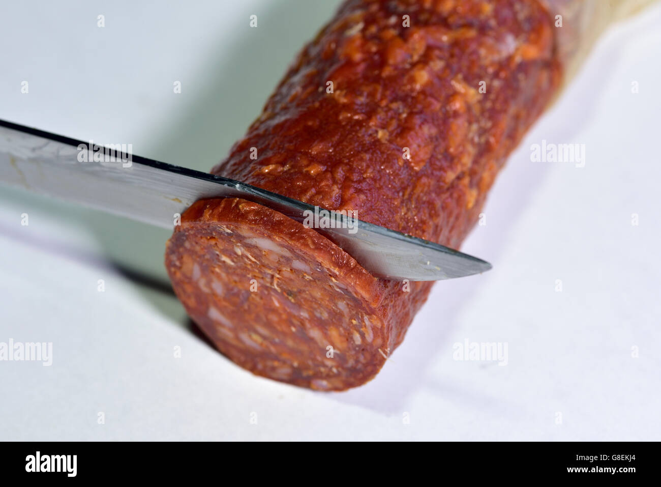 Il taglio della lama fetta di fumato il salame chorizo Foto Stock