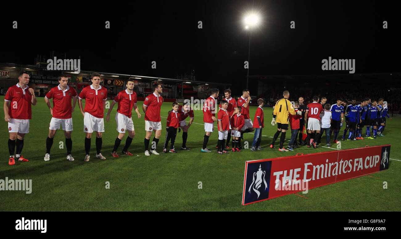 I giocatori del FC United of Manchester e del Chesterfield si stringono le mani prima della Emirates fa Cup, partita del primo round al Broadhurst Park di Manchester. Foto Stock