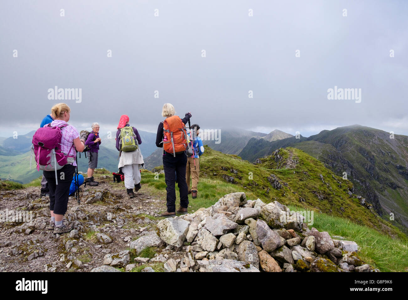 Gli escursionisti escursionismo su Am Bodach vertice di inizio di Aonach Eagach ridge guardando ad ovest. Glencoe, Highland, Scozia, Regno Unito, Gran Bretagna Foto Stock