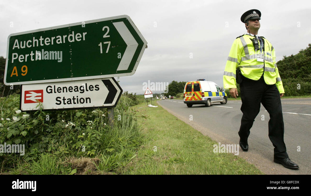 Un agente di polizia arresta il traffico intorno alla tenuta di Gleneagles mentre i preparativi finali per la sicurezza sono messi in atto nello stesso momento in cui la marcia di storia di Make Poverty è in corso a Edimburgo. Foto Stock