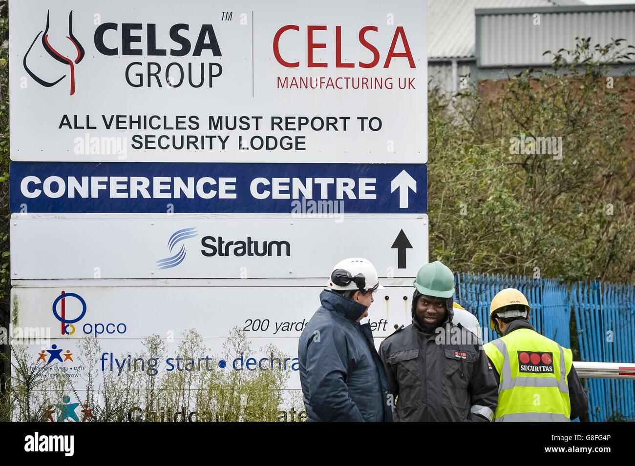 I lavoratori si riuniscono intorno al cancello di sicurezza della fabbrica di produzione di Celsa, dove i servizi di emergenza sono stati chiamati a seguito di un'esplosione. Foto Stock