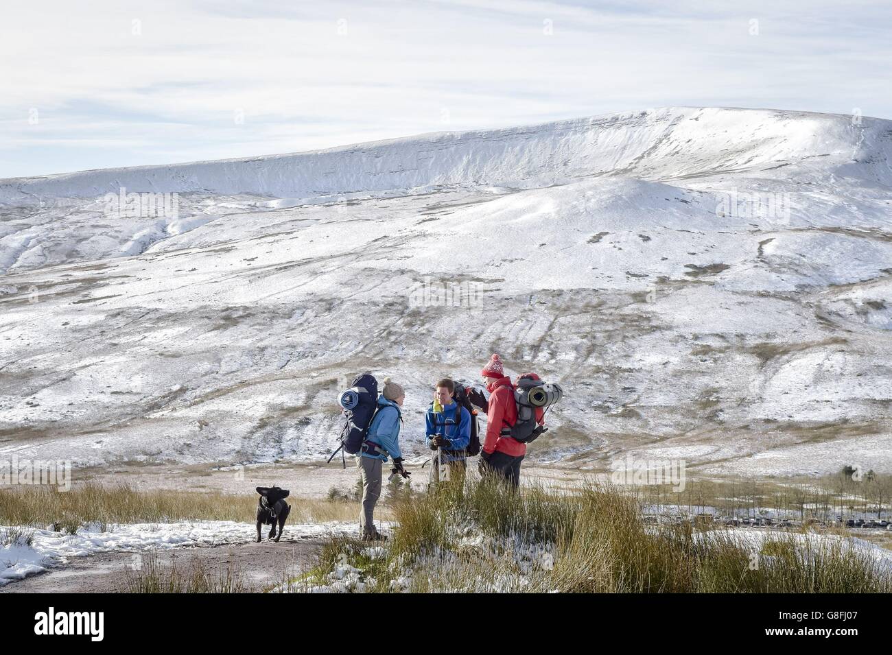 La gente fa una pausa mentre cammina sulla montagna innevata Pen y Fan nel Brecon Beacons, Galles, mentre alcune parti del Regno Unito hanno visto una raffica di neve durante la notte all'inizio di un fine settimana di viteria che poteva vedere le temperature precipitare a meno 5C. Foto Stock