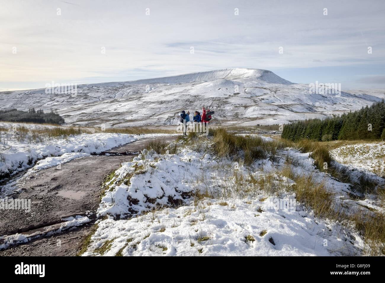 La gente fa una pausa mentre cammina sulla montagna innevata Pen y Fan nel Brecon Beacons, Galles, mentre alcune parti del Regno Unito hanno visto una raffica di neve durante la notte all'inizio di un fine settimana di viteria che poteva vedere le temperature precipitare a meno 5C. Foto Stock