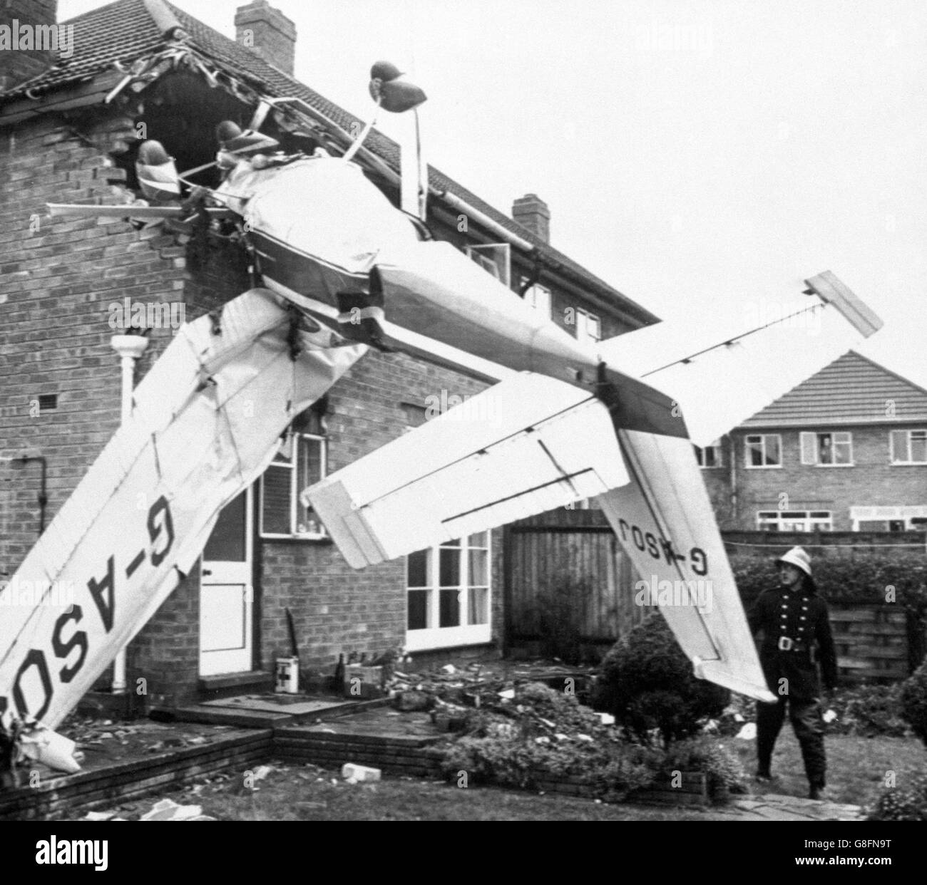 Un aereo leggero, in cui due persone sono morte, è incorporato capovolto nel lato di una casa in cui si è schiantato a Aldridge, Staffordshire. Gli occupanti della casa non sono stati feriti. Foto Stock