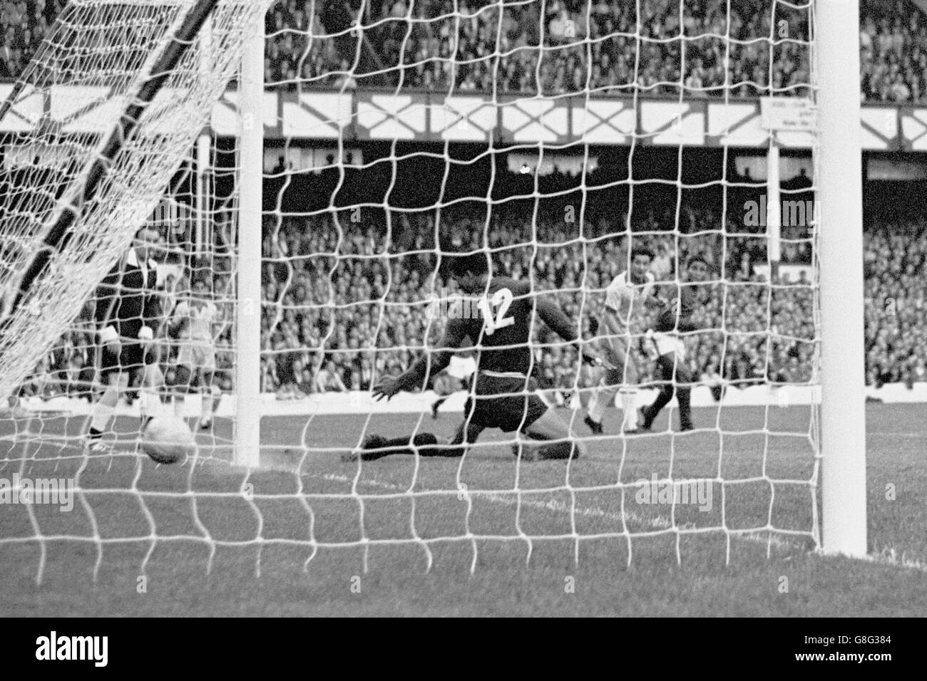 Calcio - Coppa del mondo Inghilterra 1966 - Gruppo tre - Portogallo / Brasile - Goodison Park. Eusebio (r) del Portogallo guarda come il suo colpo batte il portiere brasiliano Manga (c) per il terzo obiettivo della sua squadra Foto Stock