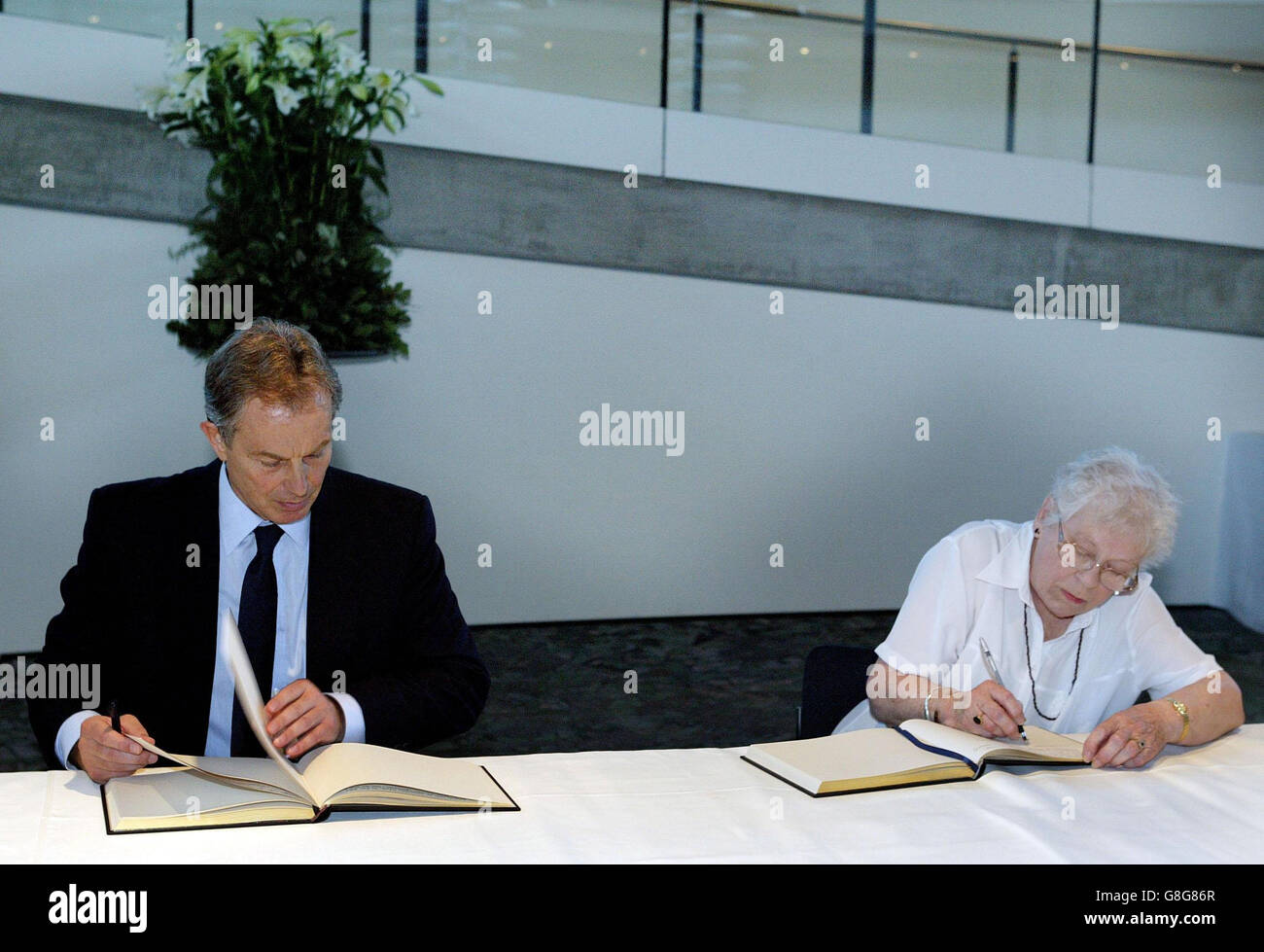Il primo ministro britannico Tony Blair firma il Libro delle condoglianze per le vittime delle esplosioni terroristiche della scorsa settimana, insieme al membro del pubblico Jean Vallaton. Foto Stock