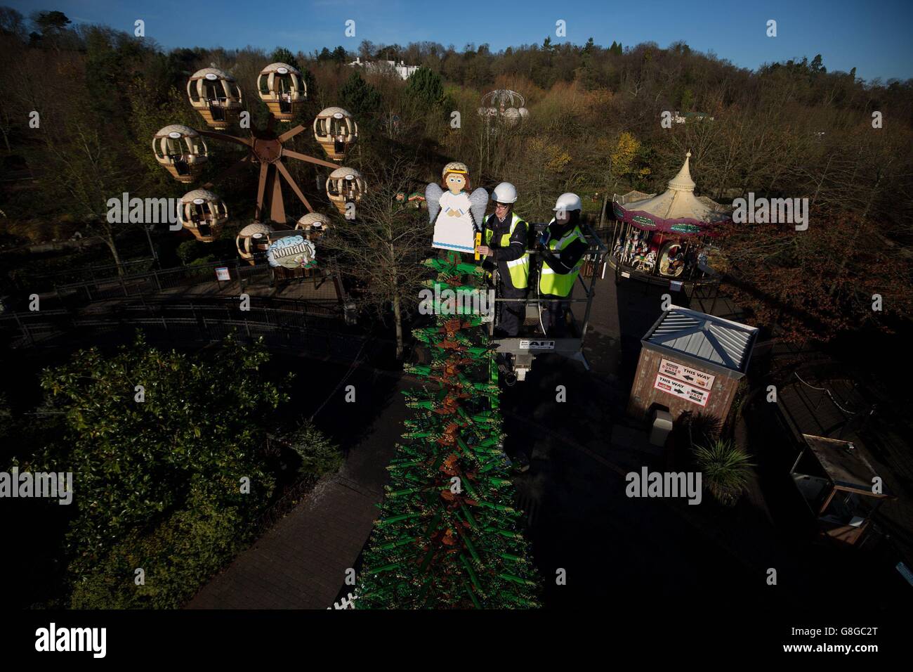 I model maker Hannah Reed (a sinistra) e Amanda Green hanno messo i tocchi finali ad un enorme LEGO Angel di 6,7 kg che si trova in cima ad un gigantesco albero di Natale alto 8 m fatto di mattoni LEGO al LEGOLAND Windsor Resort in Berkshire. Foto Stock