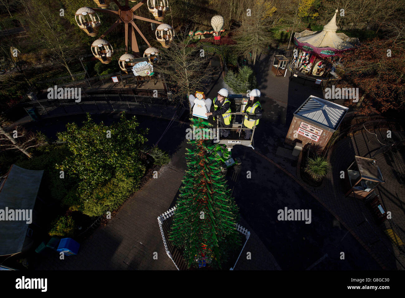 I model maker Hannah Reed (a sinistra) e Amanda Green hanno messo i tocchi finali ad un enorme LEGO Angel di 6,7 kg che si trova in cima ad un gigantesco albero di Natale alto 8 m fatto di mattoni LEGO al LEGOLAND Windsor Resort in Berkshire. Foto Stock