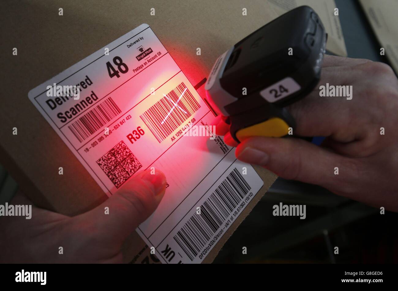 Un dipendente del Glasgow Mail Center di Royal Mail utilizza un finger  scanner per aiutare un cliente a tenere traccia della consegna di un pacco,  in quanto il centro gestisce milioni di