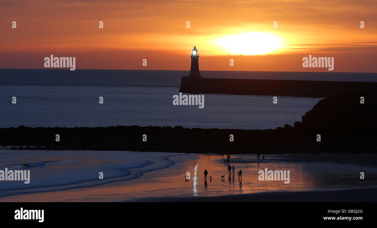 La gente guarda il sole sorgere il giorno di Natale sulla spiaggia a Tynemouth in Tyne e indossare. Foto Stock