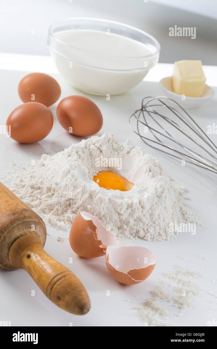 Uova, farina, latte, burro e utensili da cucina Foto Stock