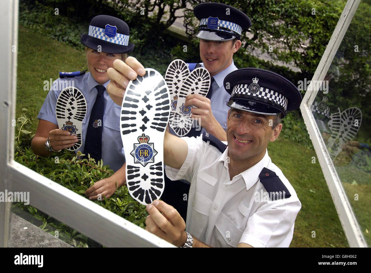 Bournemouth Crime Reduction Officer PC Ian Curtis con polizia Comunità di supporto ufficiali Rob Castell e Michelle Carpenter e l'impronta a forma di volantini Dorset Police stanno distribuendo attraverso finestre e porte di proprietà insicure come parte di una campagna lanciata per ridurre burglaries estate. Foto Stock