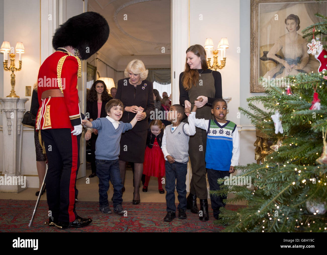 La Duchessa di Cornovaglia decora l'albero di Natale della Clarence House con l'aiuto di (da sinistra a destra) Orr Bar-on (7), Kiera Holland (5) e dei gemelli Adam e Aten Ndaka (5), bambini sostenuti da Helen & Douglas House e dal London Taxi Drivers' Fund for UnderPrivileged Children. Foto Stock