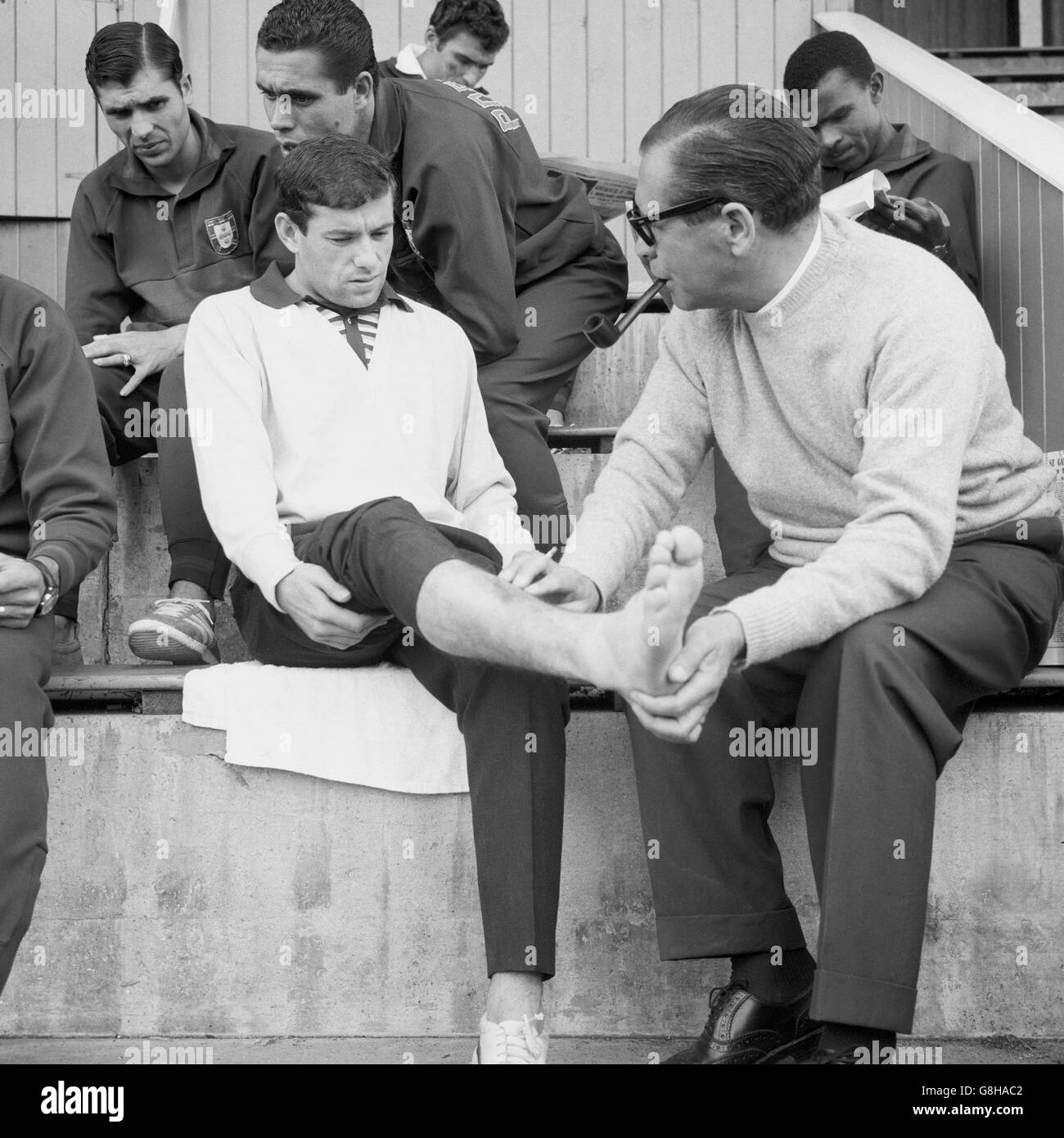 Calcio - Coppa del mondo Inghilterra 1966 - Portogallo Training - Cheadle. Il dottore portoghese Silva Rocha (r) esamina la gamba destra ferita di Antonio Simoes (l) dopo l'allenamento Foto Stock