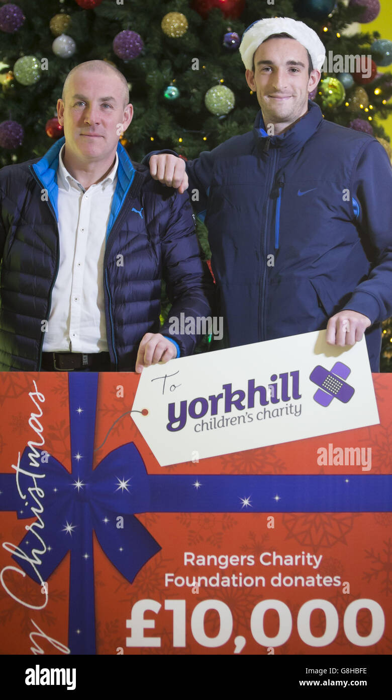 Il manager del Rangers Football Club Mark Warburton (a sinistra) e il capitano Lee Wallace donano &Pound;10,000 a Yorkhill Children's Charity per conto della Rangers Charity Foundation, durante una visita al Royal Hospital for Children di Glasgow. Foto Stock