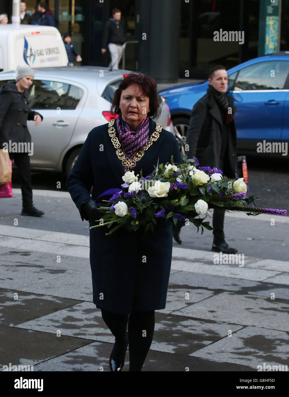 Lord Provost of Glasgow Sadie Dochrety depone fiori insieme ad altri tributi lasciati in Royal Exchange Square per celebrare l'anniversario del crollo dei camion a bin di Glasgow, che ha ucciso sei persone e ha ferito molte altre. Foto Stock