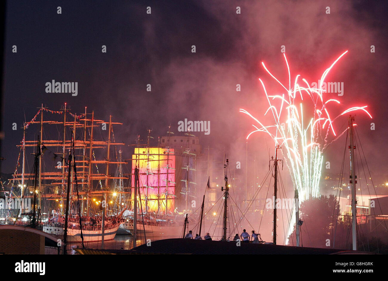 I membri dell'equipaggio guardano una mostra di fuochi d'artificio presso il Quayside. Foto Stock