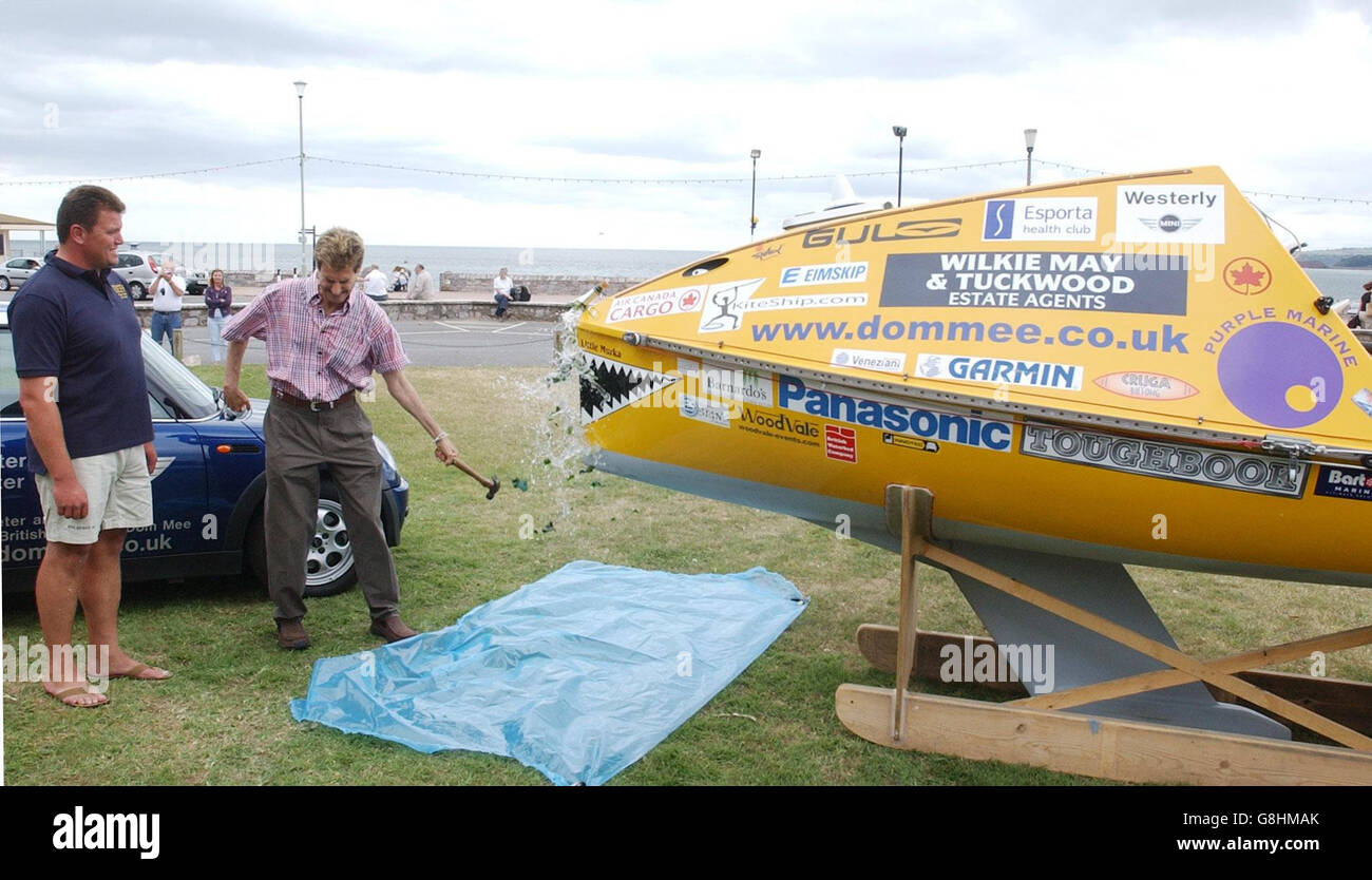 Dom Mee (L) guarda come Uri Geller distruggi una bottiglia di champagne alla cerimonia di denominazione della sua barca, Little Murka, a Exmouth, Devon. L'eccentrico avventuriero Mee ha annunciato oggi la sua ultima bizzarra stunt, per attraversare l'Atlantico settentrionale nell'unica barca al mondo alimentata da aquiloni. L'ex comandante reale della Marina Mee, 34, ha in programma di stabilire un nuovo record mondiale quando salpa nella sua piccola barca il 15 agosto. Mee, da West Buckland, vicino a Wellington, Somerset, salperà da St Johns a Terranova, Canada. Foto Stock