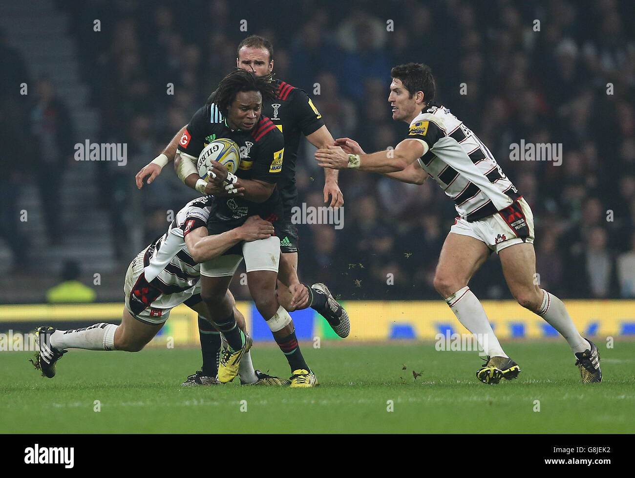 Harlequins Marland Yarde è combattuto da Billy Twelvetrees di Gloucester Rugby e James Hook durante la partita Aviva Premiership al Twickenham Stadium, Londra. Foto Stock