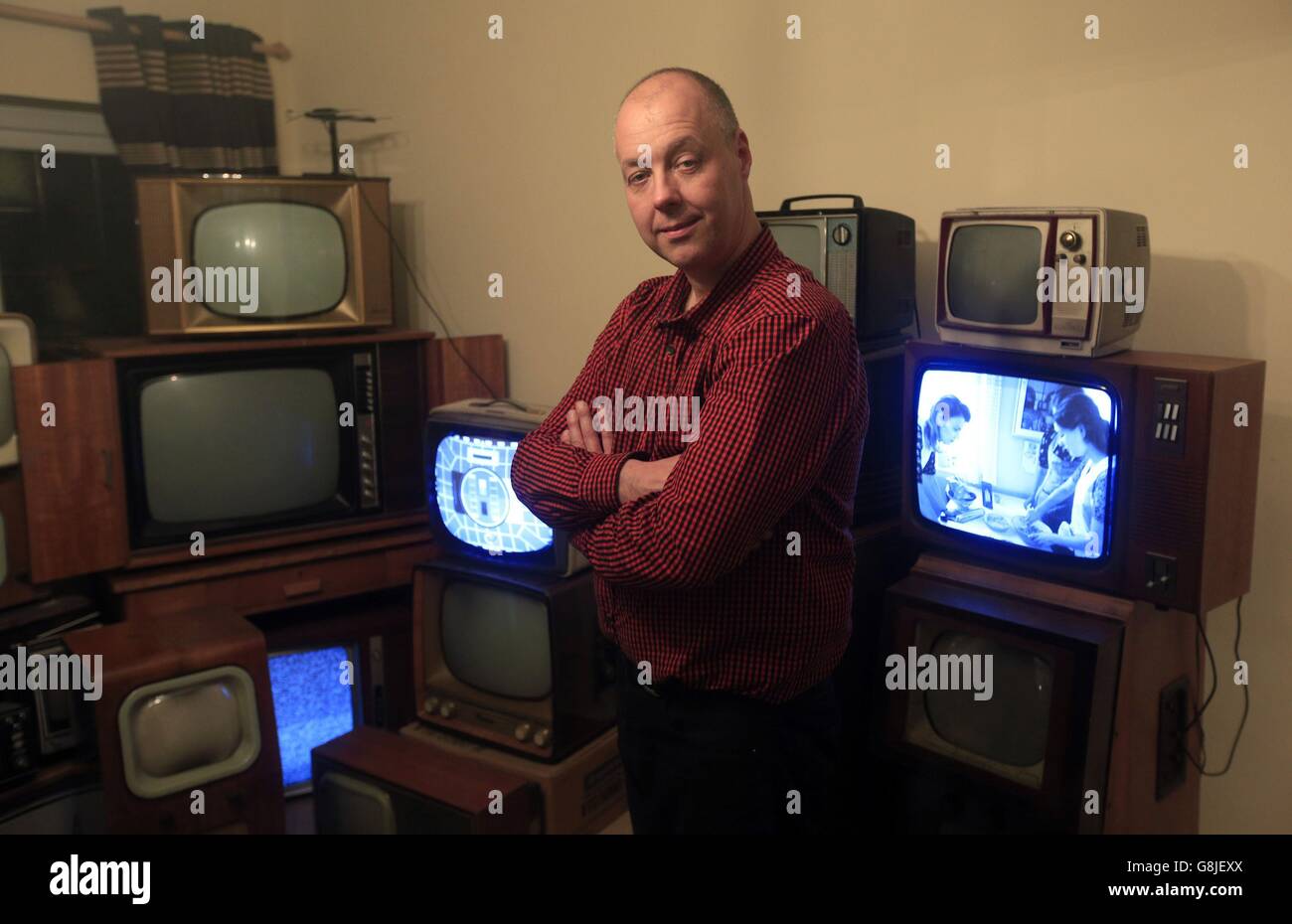 John Thompson si trova tra le parti della sua collezione di televisori vintage in bianco e nero a casa sua a Enfieldm, a nord di Londra, Migliaia di britannici hanno chiuso gli occhi sulle tendenze dei TV ad alta definizione e dei programmi in streaming sui tablet a favore del vecchio set in bianco e nero. Foto Stock