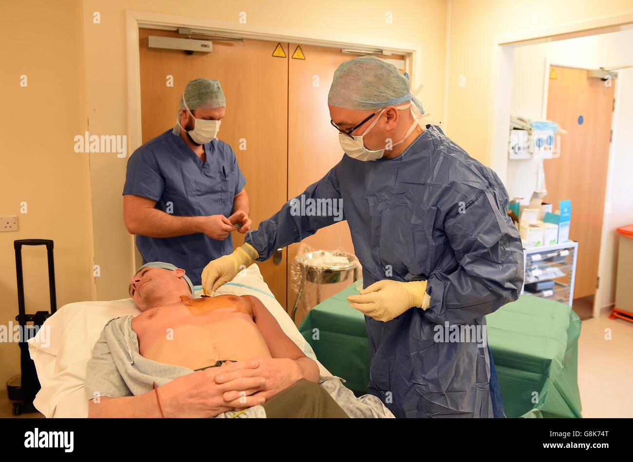 Poole Hospital Consultant cardiologo Dr Christopher Boos prepara il petto del chirurgo Comandante Adrian Mellor, Chi è il leader della mostra del team di British Services Dhaulagiri Medical Research Expedition 2016, prima di iniettare un monitor cardiaco Reveal LINQ che verrà utilizzato per controllare il suo cuore mentre il suo team salirà sul massiccio di Dhaulagiri. Foto Stock