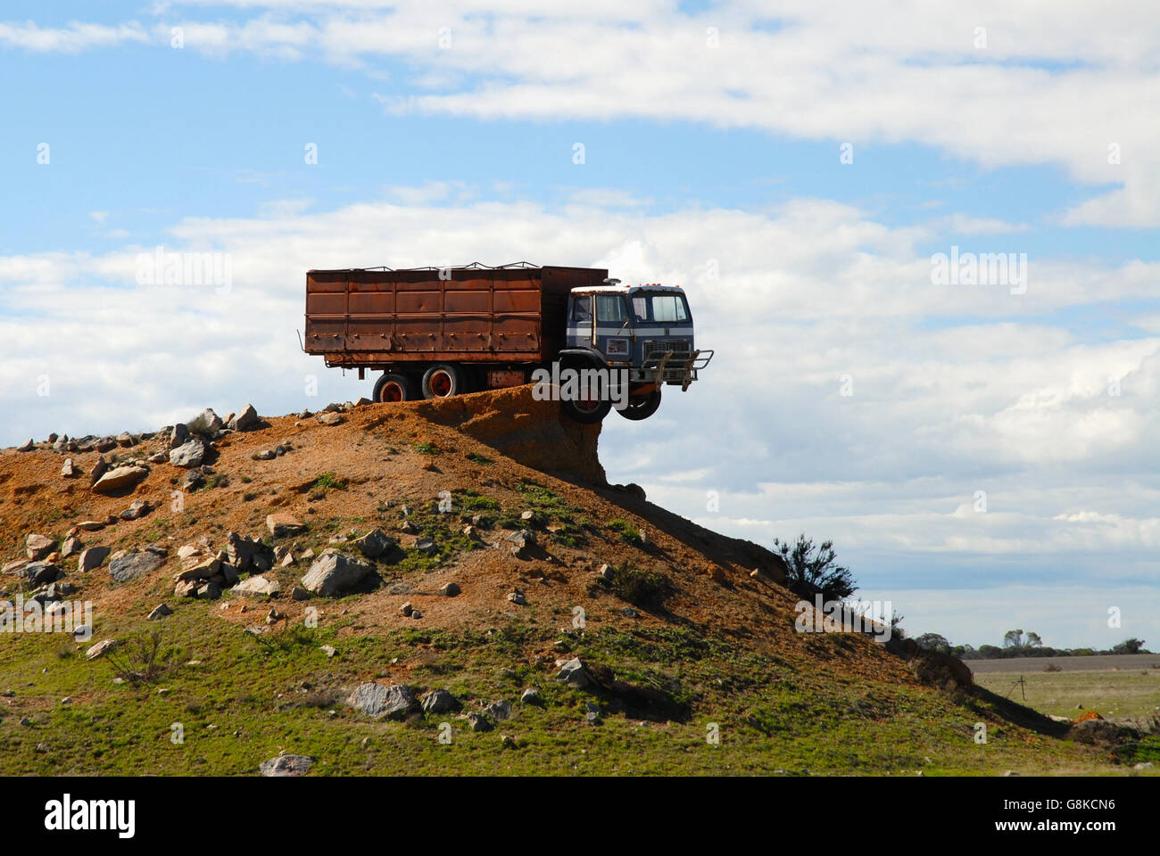 Grandi camion bloccato sulla sommità di un grande cumulo di rocce e di sporco. L'Outback australiano. Foto Stock