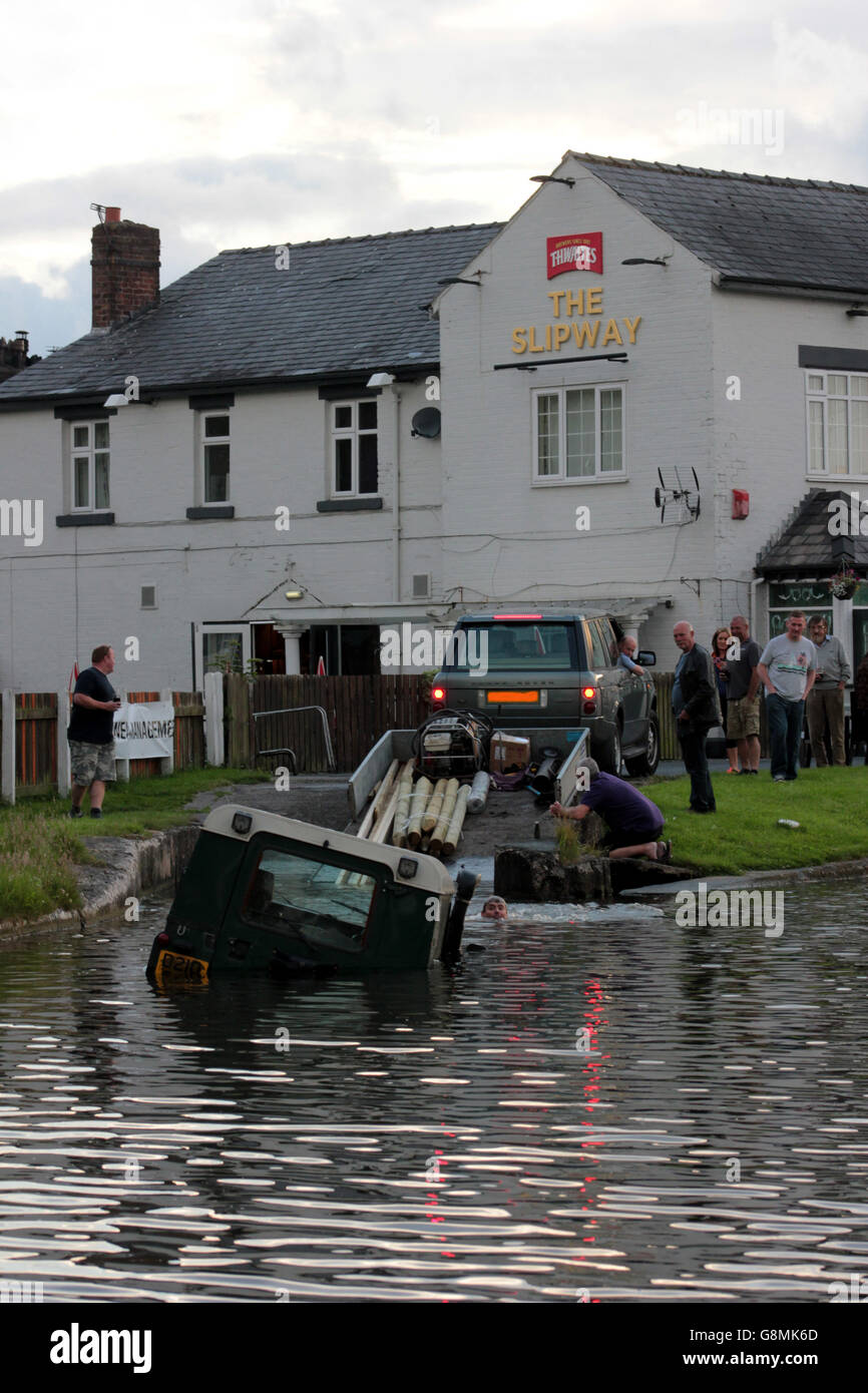 A Land Rover is recovered from Leeds and Liverpool canal at The Slipway pub near Burscough in Lancashire. Foto Stock