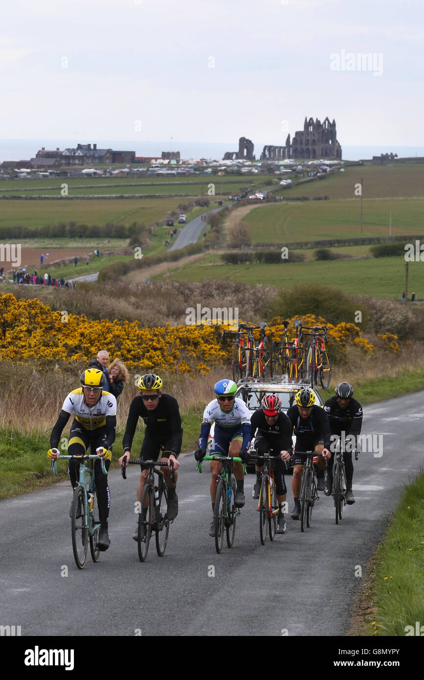 Il peloton, con la famosa abbazia dietro di loro, rende il modo fuori di Whitby nel finale di tappa del Tour de Yorkshire. Foto Stock