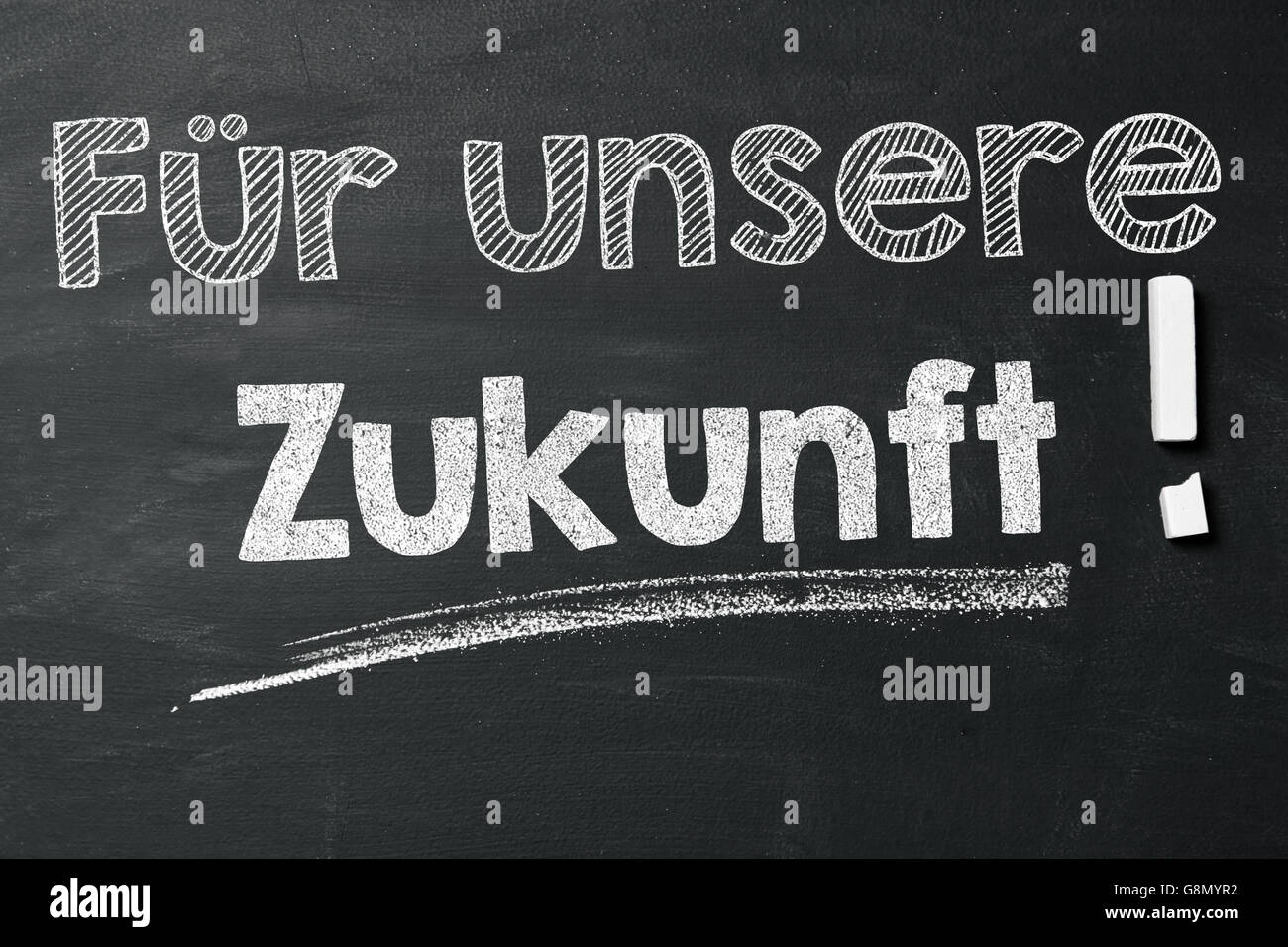 Espressione tedesca "Für unsere Zukunft!" (per il nostro futuro!) con un gessetto sulla lavagna Foto Stock