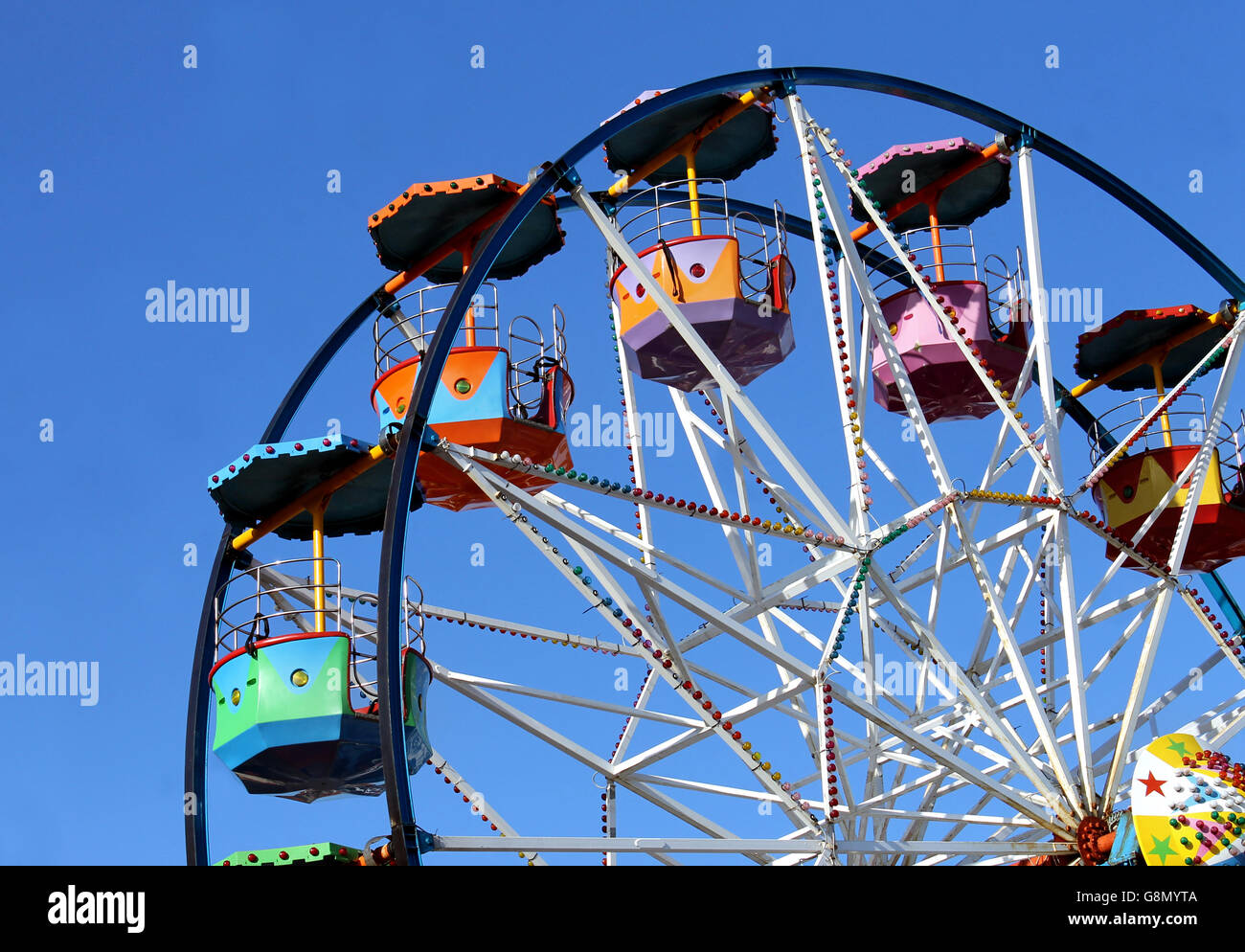 Coloratissima ruota panoramica Ferris con cielo blu sullo sfondo. Foto Stock
